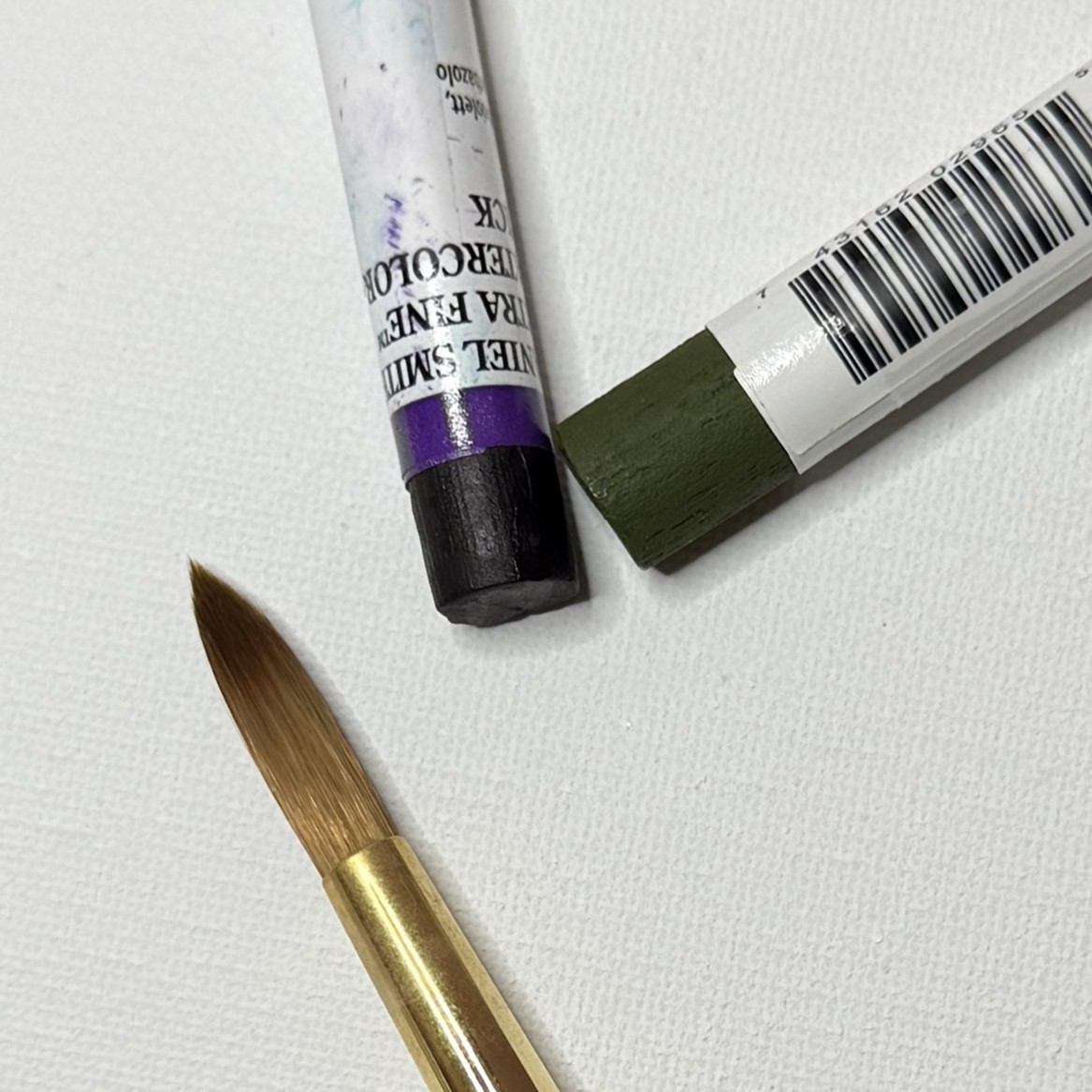 an image showing watercolor sticks and a brush on a canvas